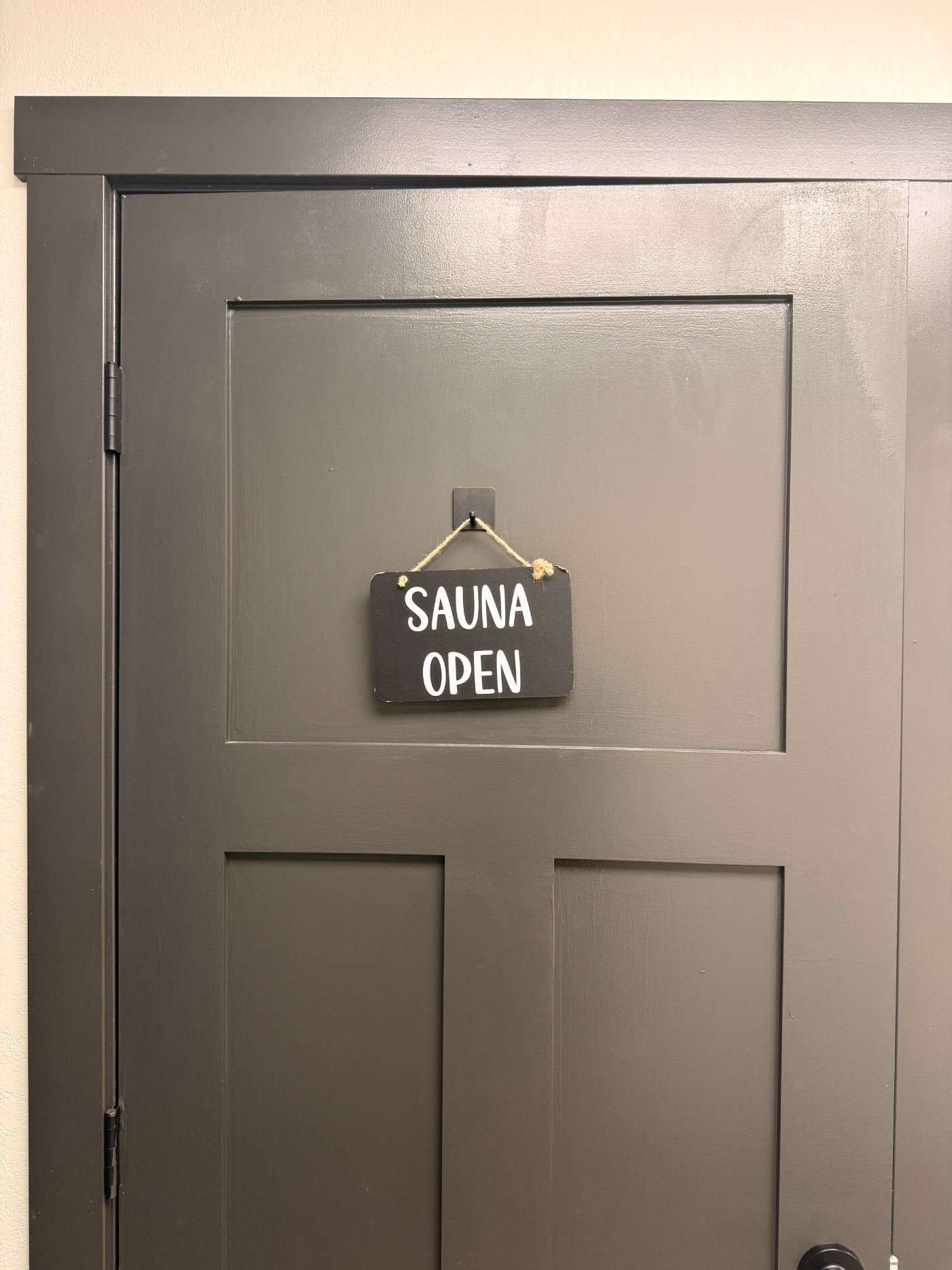 Sauna open sign hanging on the sauna door