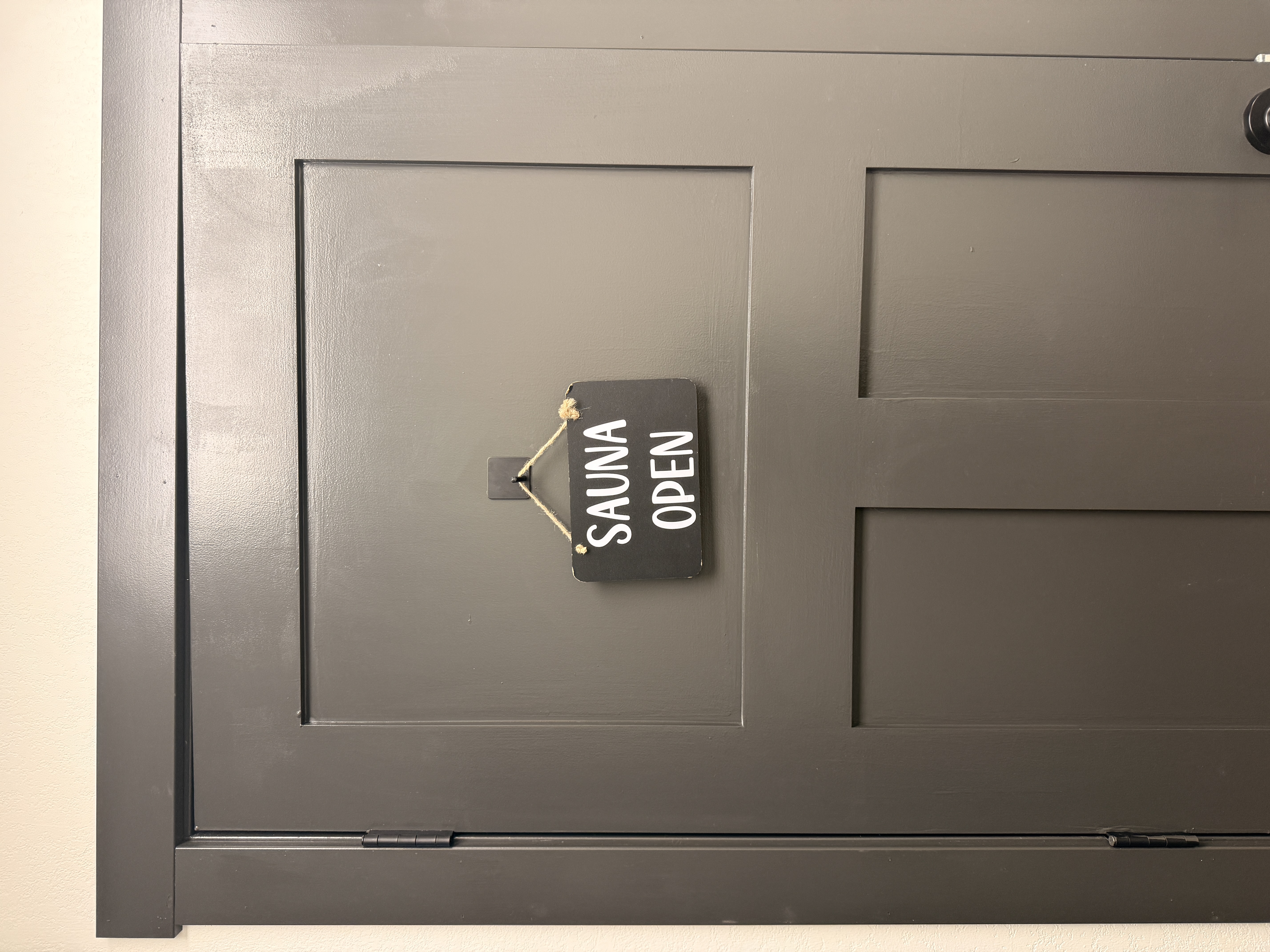 Sauna open sign hanging on the sauna door
